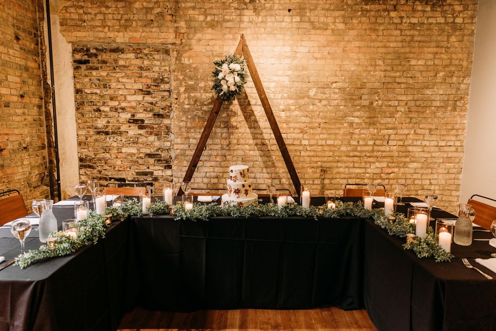 Exposed brick walls and string lights create a rustic ambiance in an indoor event space.