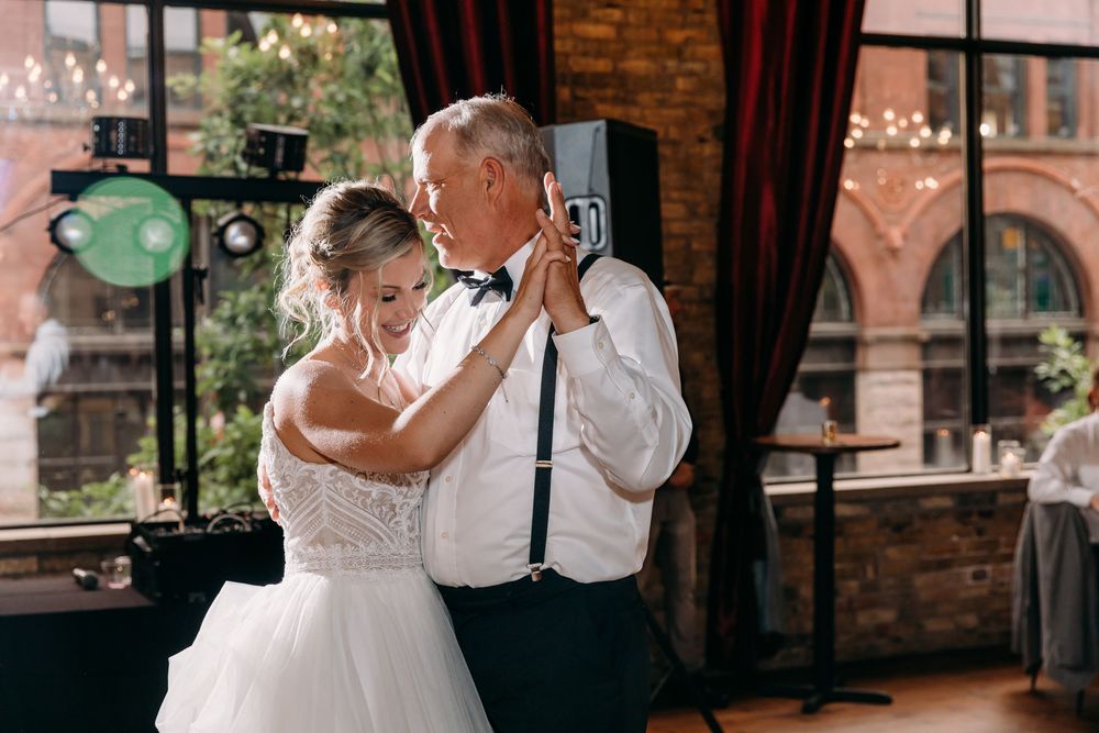 Bride and groom share romantic moments in a rustic brick venue during their wedding celebration.