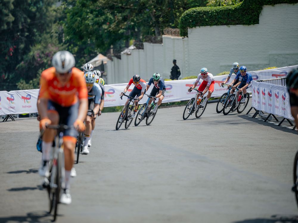 Professional cyclists navigate a tight corner during a high-speed road race competition.