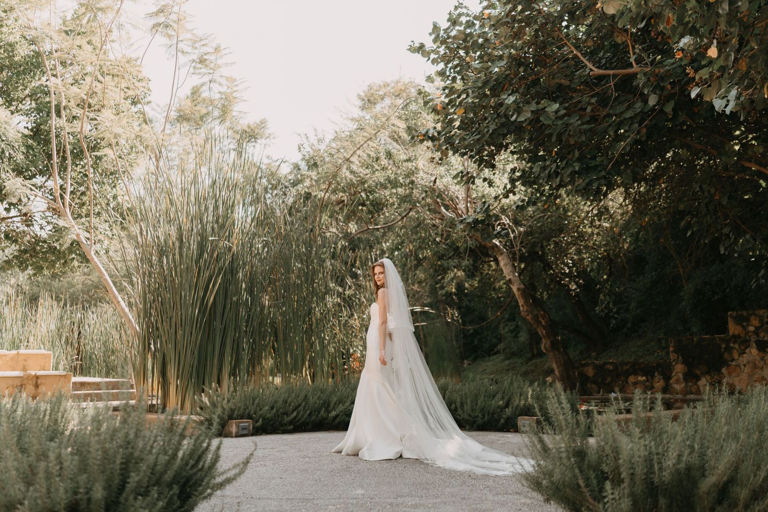 A romantic garden wedding ceremony setup with white chairs and floral arrangements in a lush outdoor setting.