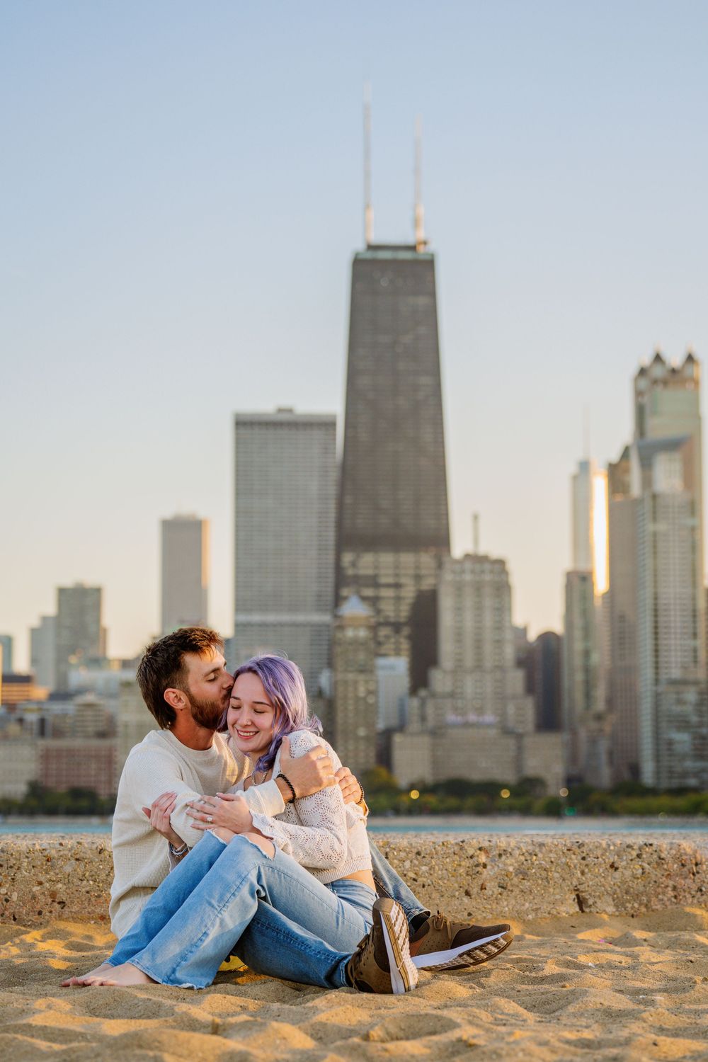 Couple sits together on North Avenue Beach with iconic Chicago skyline view.