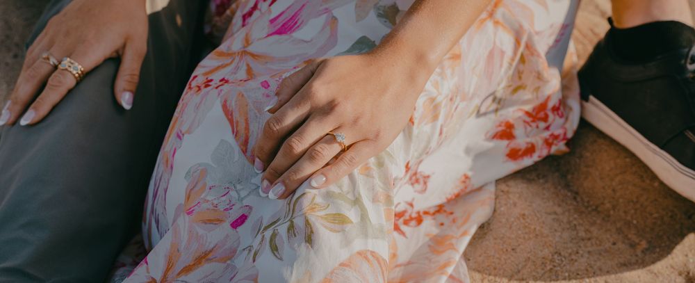 Delicate hands displaying engagement ring details.