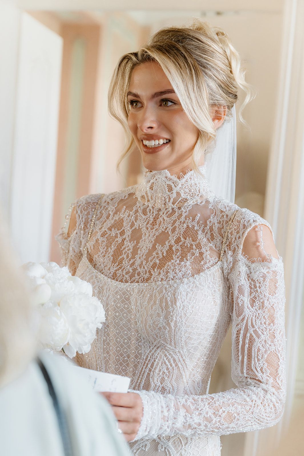 Close-up details of an elegant lace wedding dress with long sleeves and delicate floral patterns.