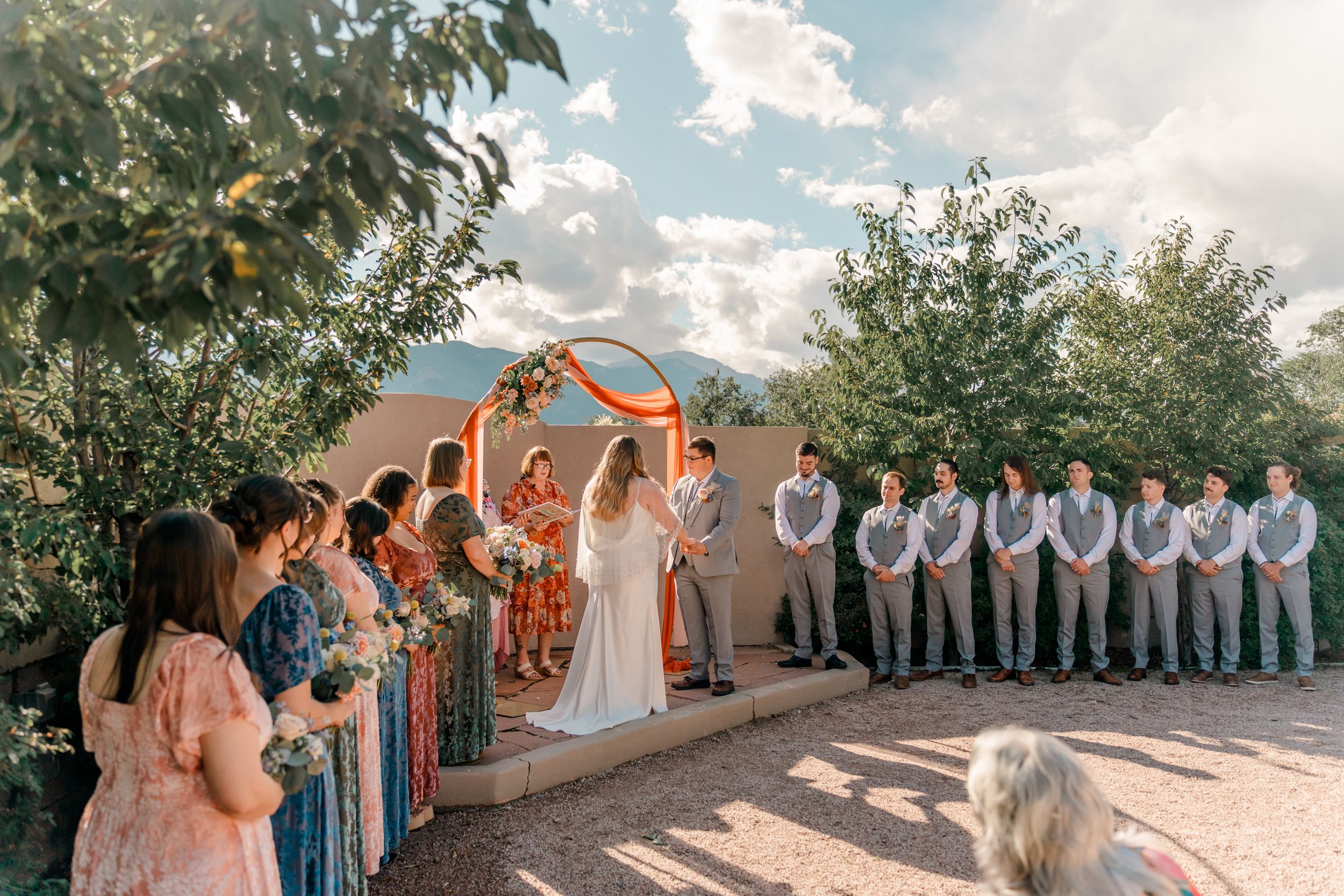 A panoramic collage of an outdoor wedding ceremony with guests gathered under a sunny sky against mountain scenery.