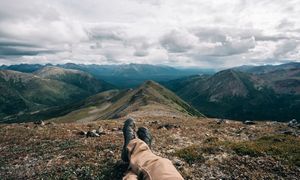 Panoramic mountain vista showing rocky peaks and valleys under cloudy skies.