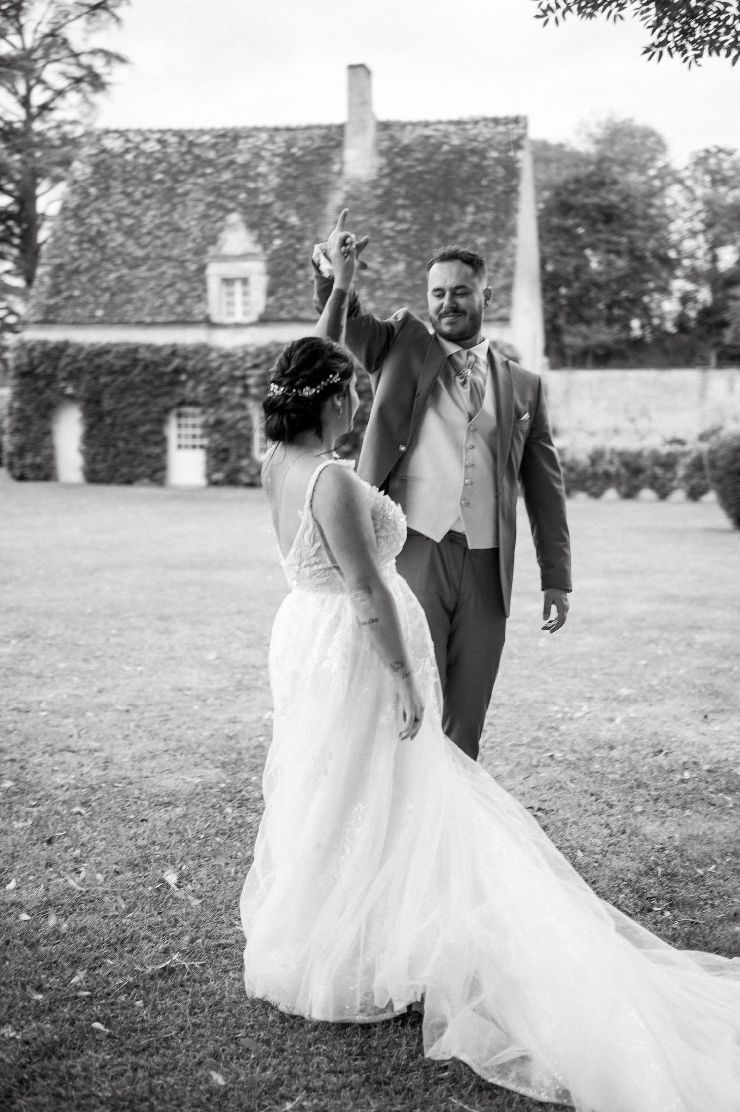 Couple de mariés tournoyant devant un manoir de Touraine ; reportage photo documentaire et patrimonial