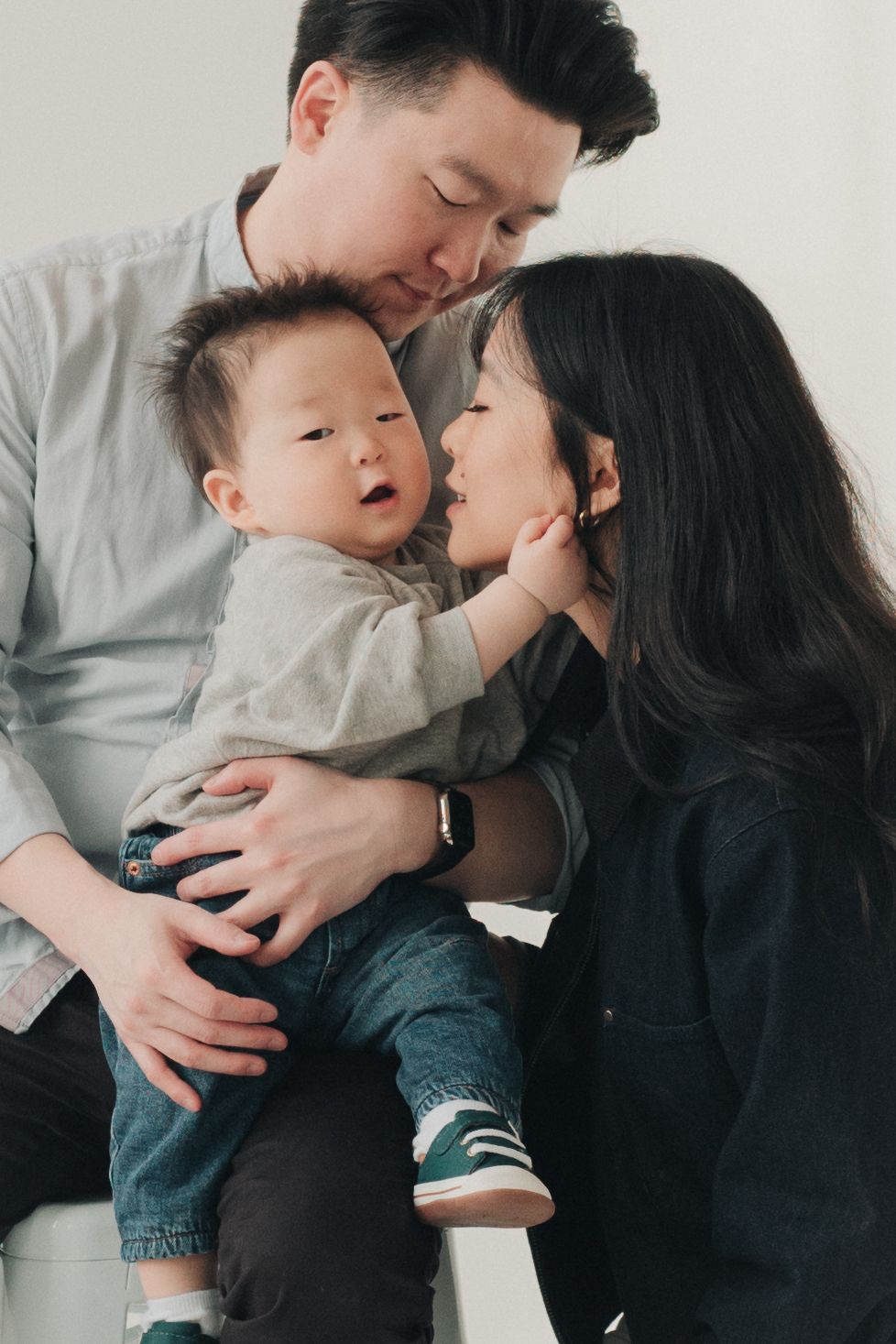 A tender moment between parent and child captured in a series of black and white family portraits.