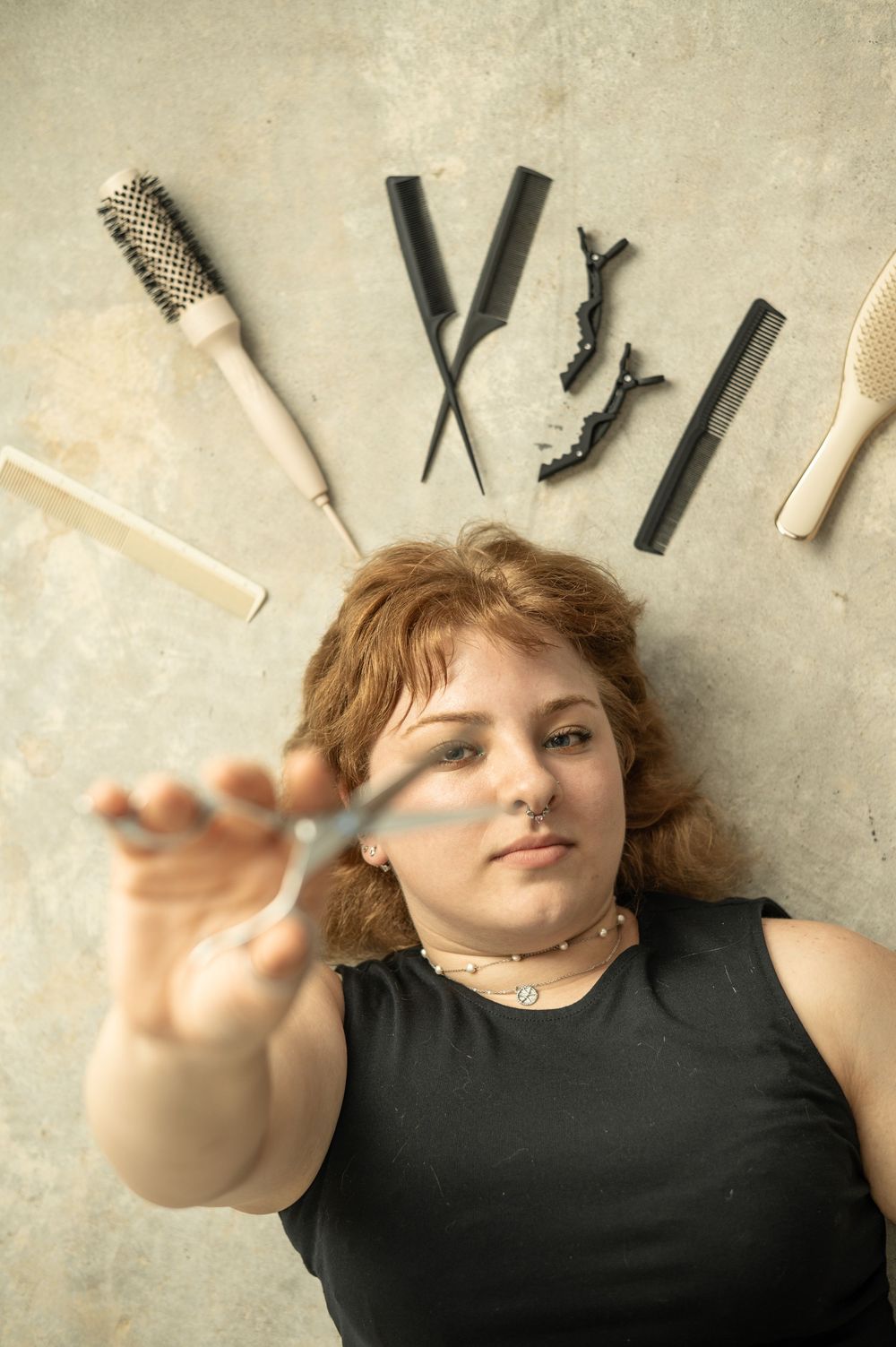 A series of four progressive photographs showing hands arranging black hair styling tools against a beige background.