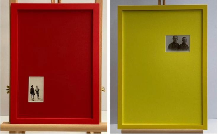 A series of red and yellow gallery walls with small framed artworks displayed in a minimalist exhibition space.