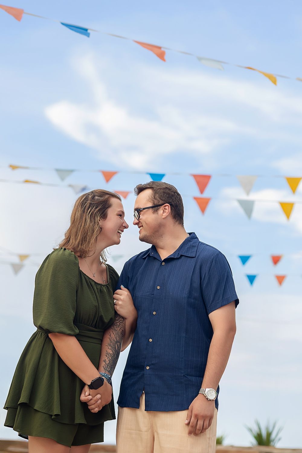 Smiling couple under festive flags in Isla Mujeres streets.