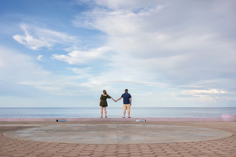Panoramic view of a tranquil beach scene with distant figures walking along the shoreline.