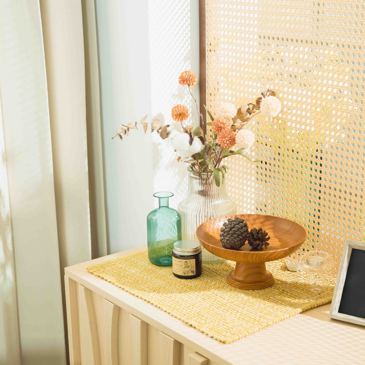 Panoramic view of a modern minimalist room with large windows, woven pendant light, and wooden accent wall.