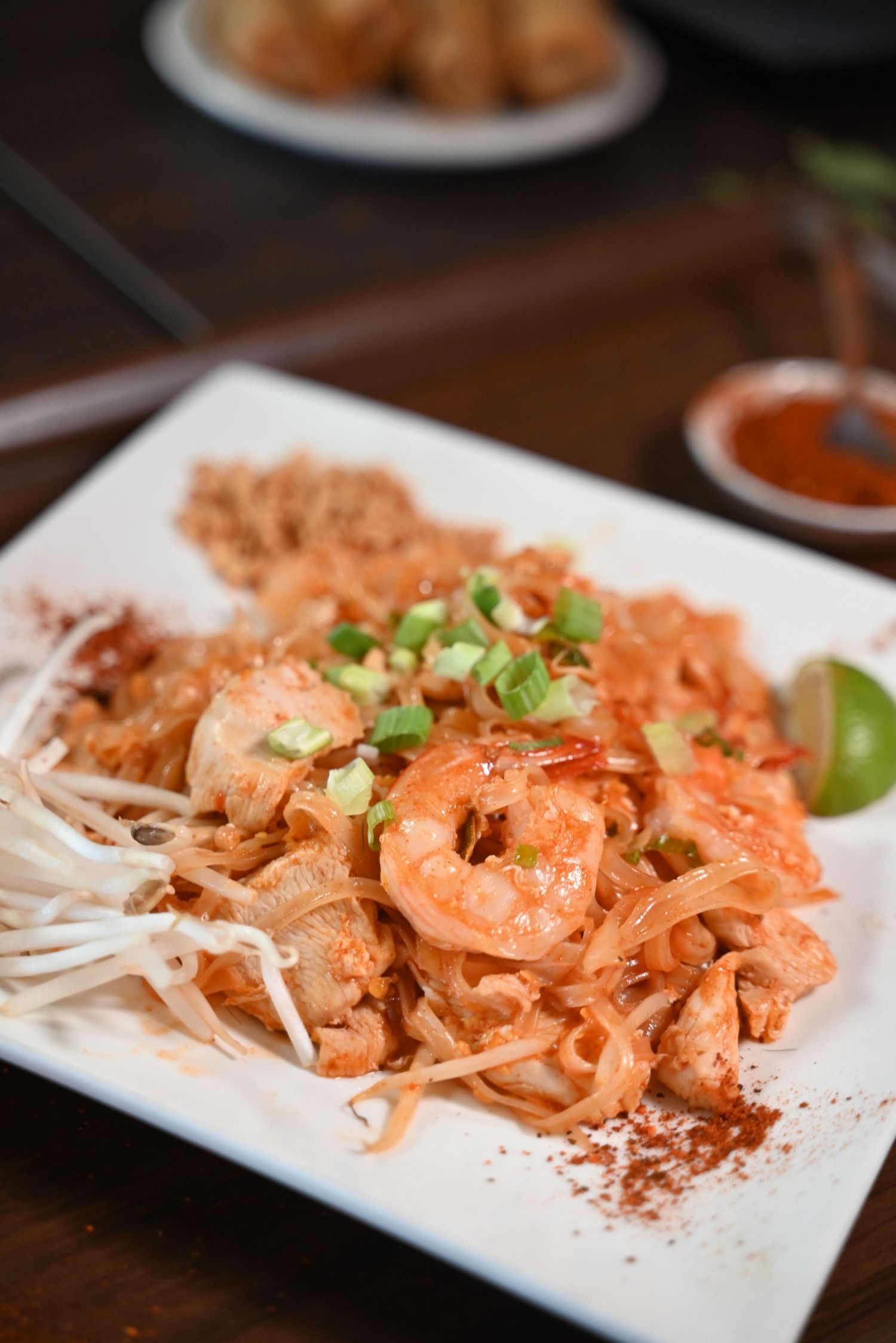 Spicy shrimp dish garnished with green onions served on a white rectangular plate in a sequence of presentation shots.