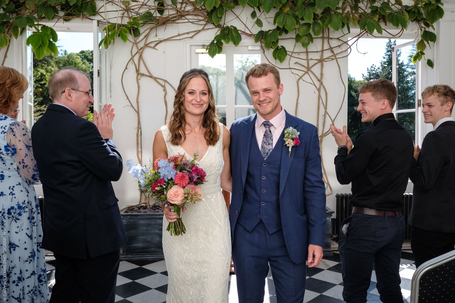 A sequence of wedding celebrations showing couples and guests in a beautifully decorated venue with greenery and flowers.