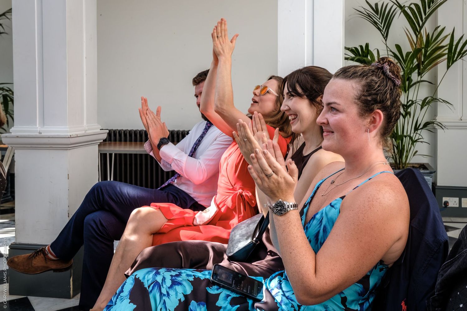 People participating in a fitness exercise class doing synchronized stretching movements on yoga mats.