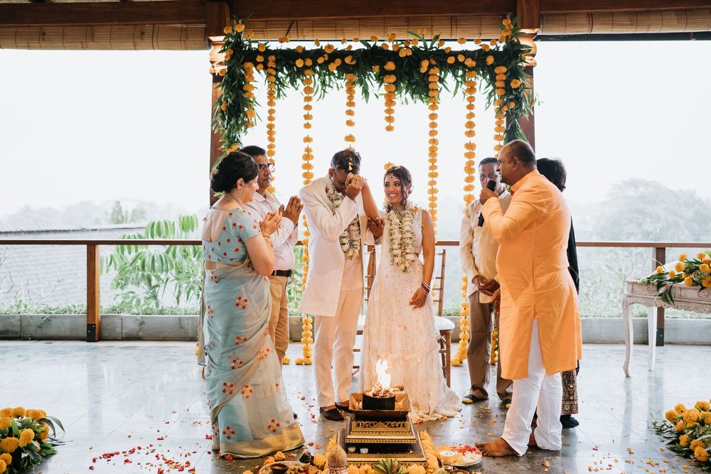 Wedding ceremony space with traditional orange marigold decorations and guests gathering for celebrations.