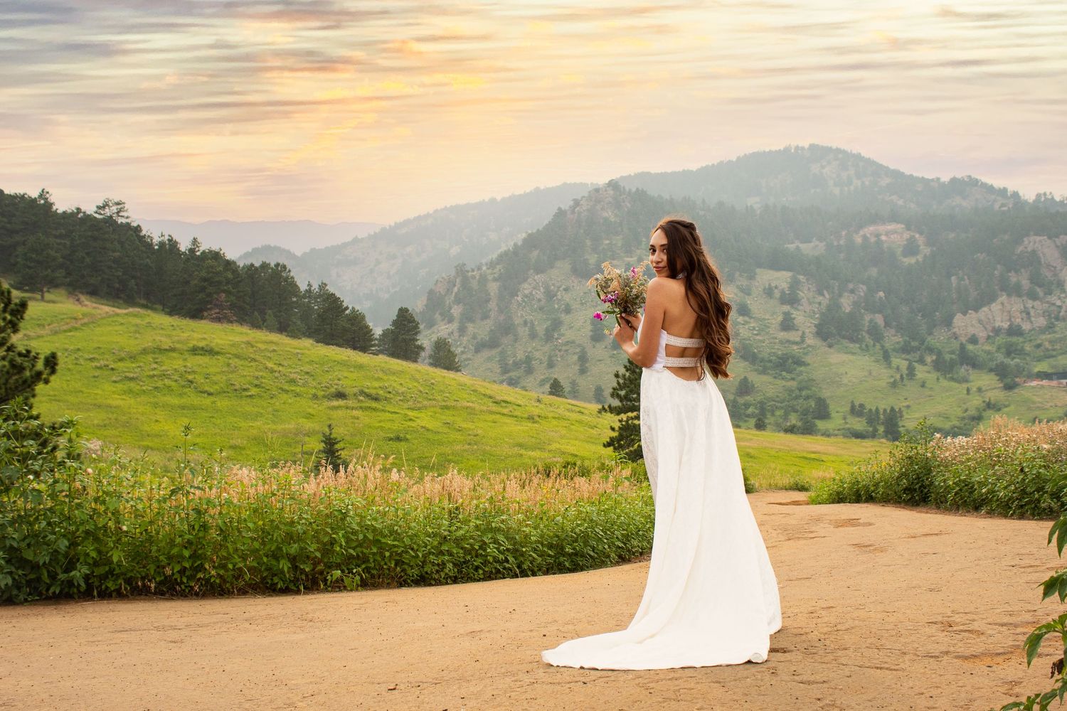 A scenic mountain landscape wedding photoshoot at sunset with rolling hills and golden light.