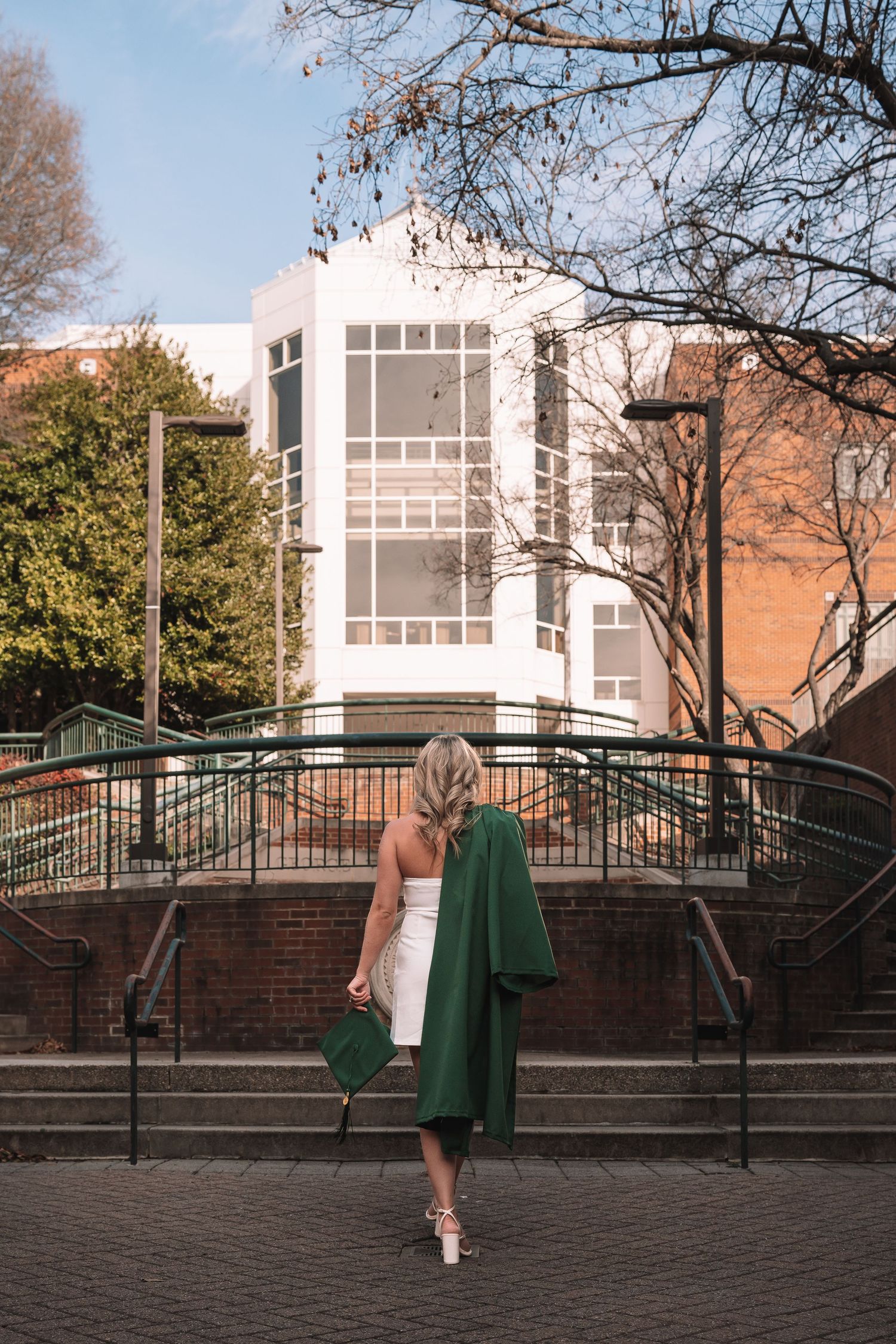 George Mason University graduation photos in brick courtyard with graduate in green dress and cap | Fairfax, Virginia senior session.