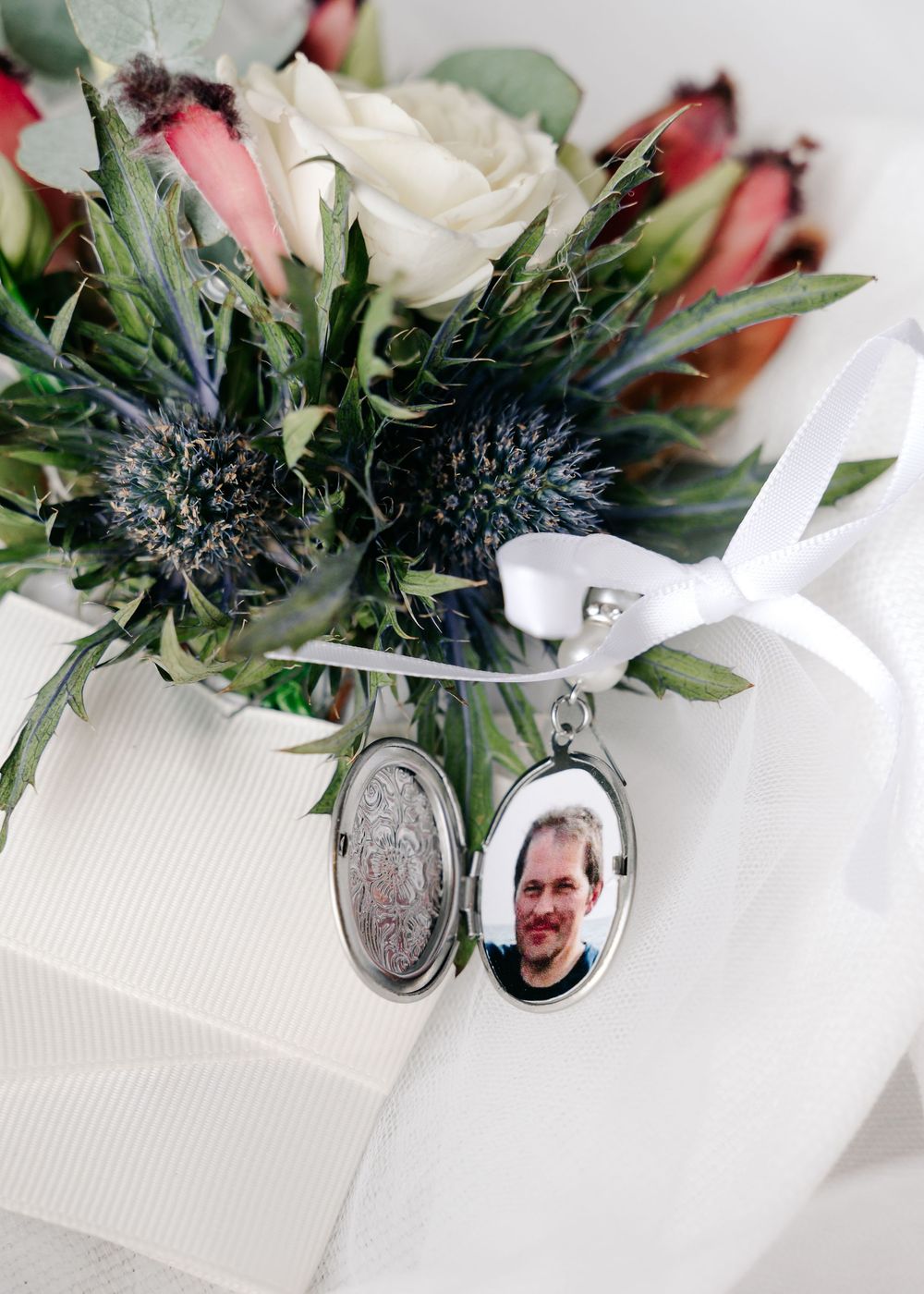 Wedding bouquet with locket charms and personal mementos attached to the stems.