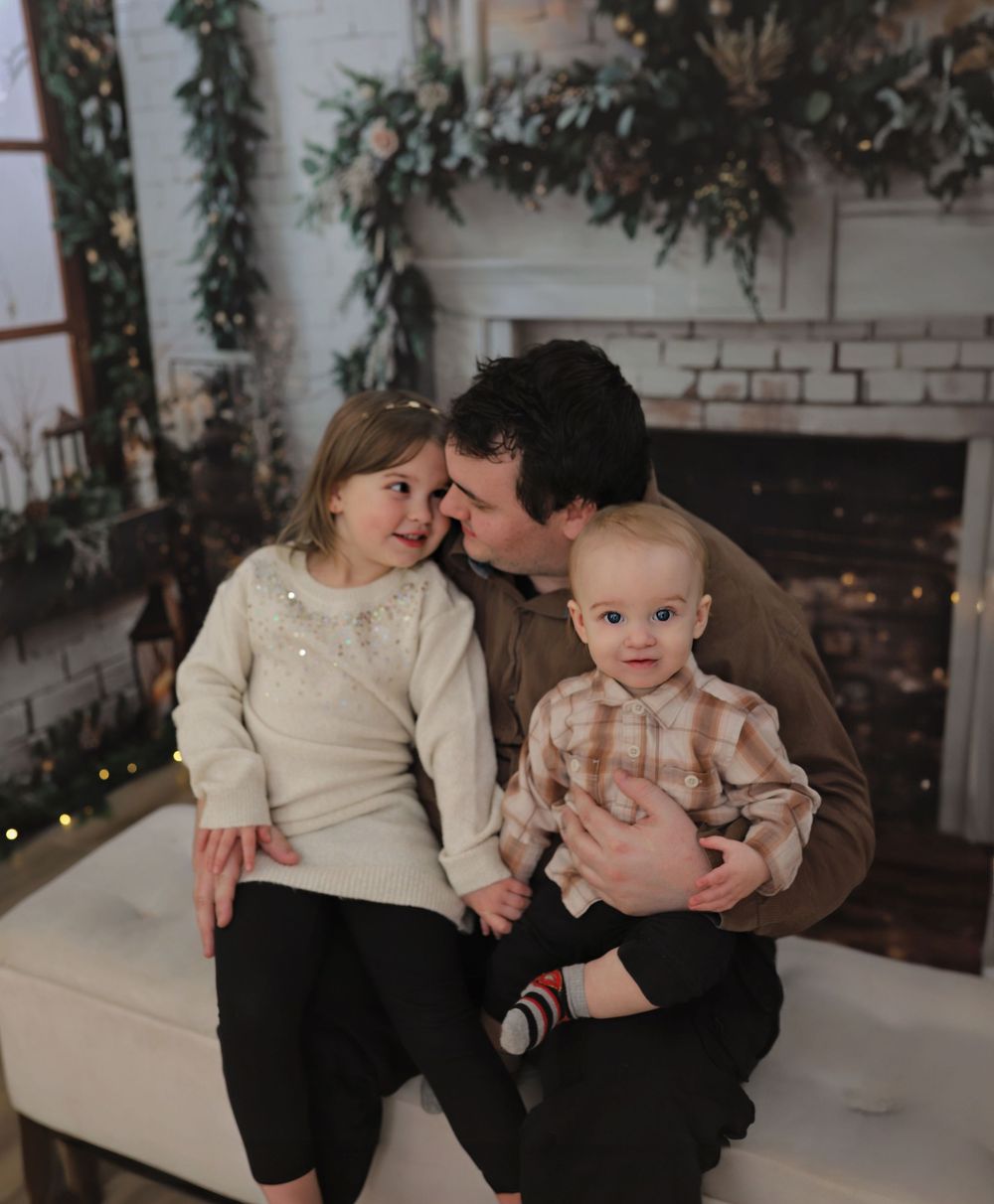 A series of intimate family portraits taken in a cozy indoor setting with holiday greenery and decorations.