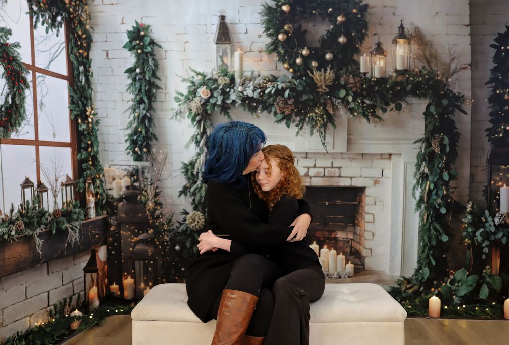 Casual indoor photoshoot with holiday decor and white stone fireplace backdrop.
