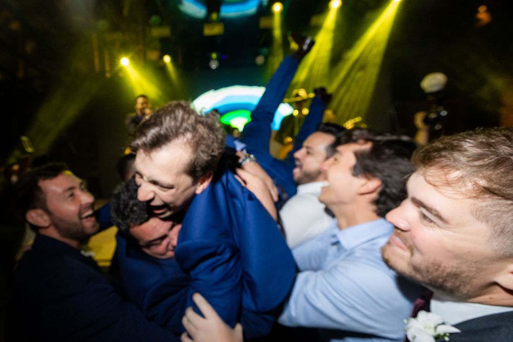 A blurred sequence of nightclub dance floor photos with people dancing and moving under yellow lighting effects.