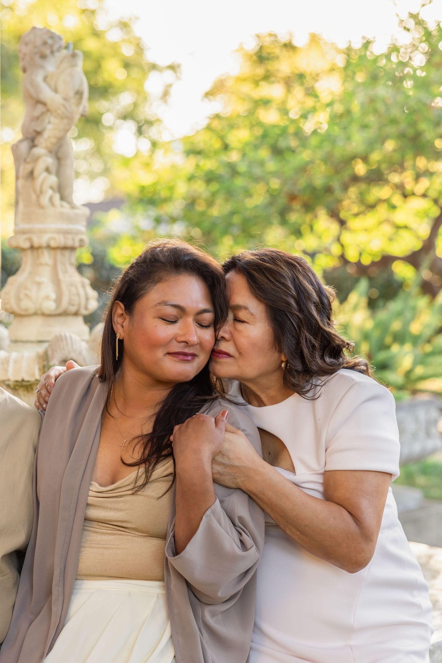 Two people sharing intimate moments while sitting outdoors during golden hour.