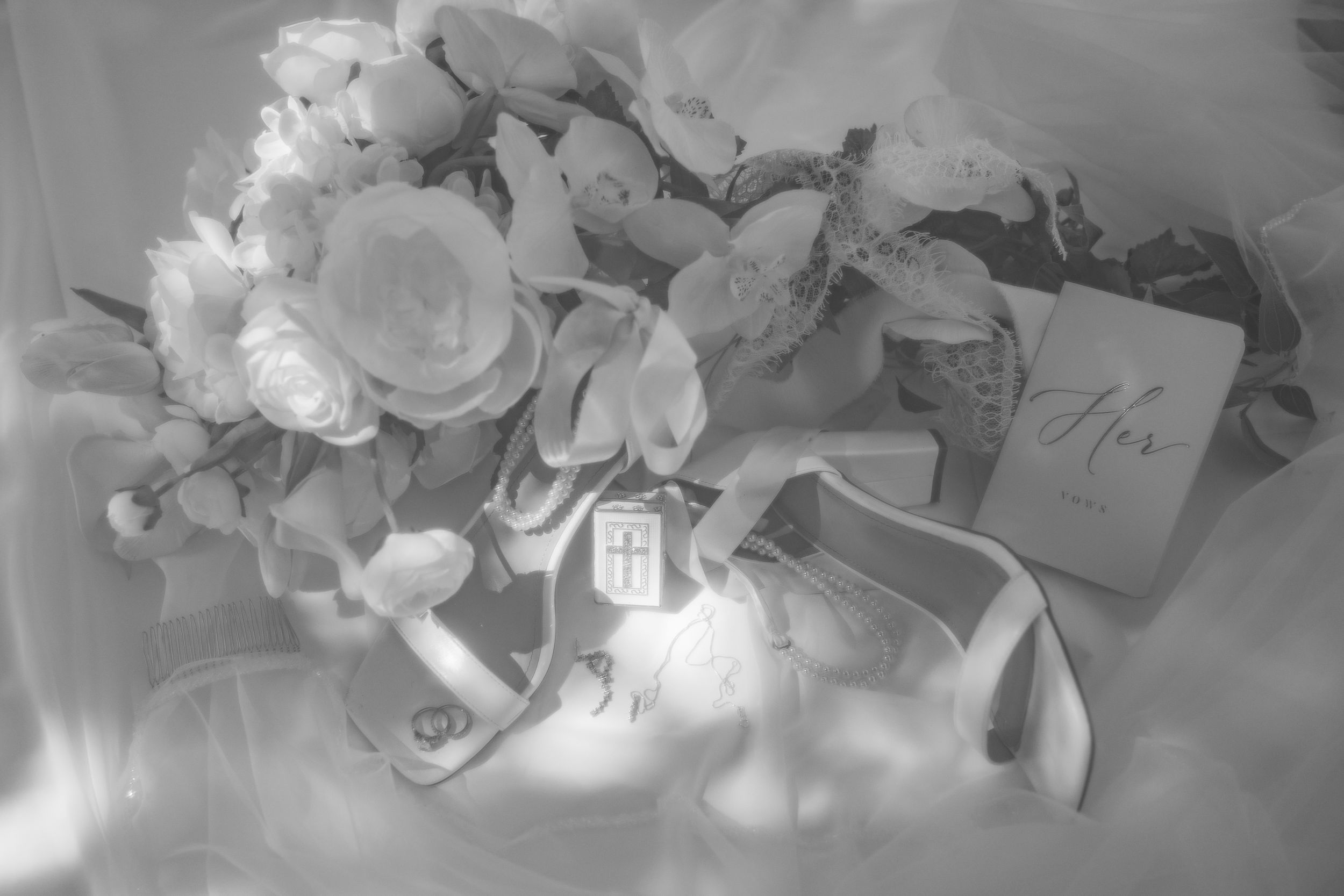 White floral arrangements and delicate table decor create an elegant wedding reception setting in soft lighting.