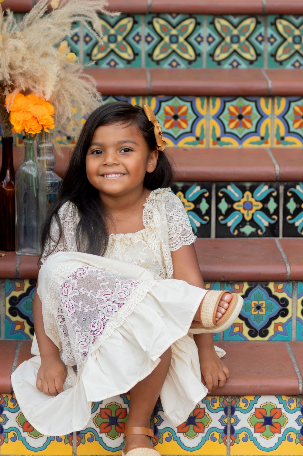 Decorative tile steps create colorful backdrop for white lace dress portrait session.