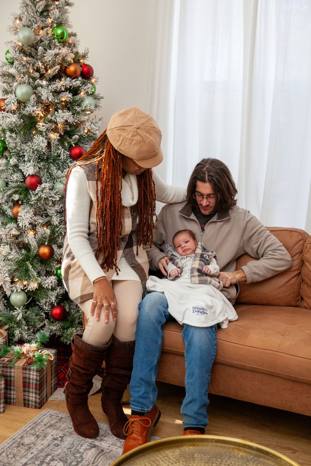 Holiday family photos being taken by a decorated Christmas tree in a cozy living room.
