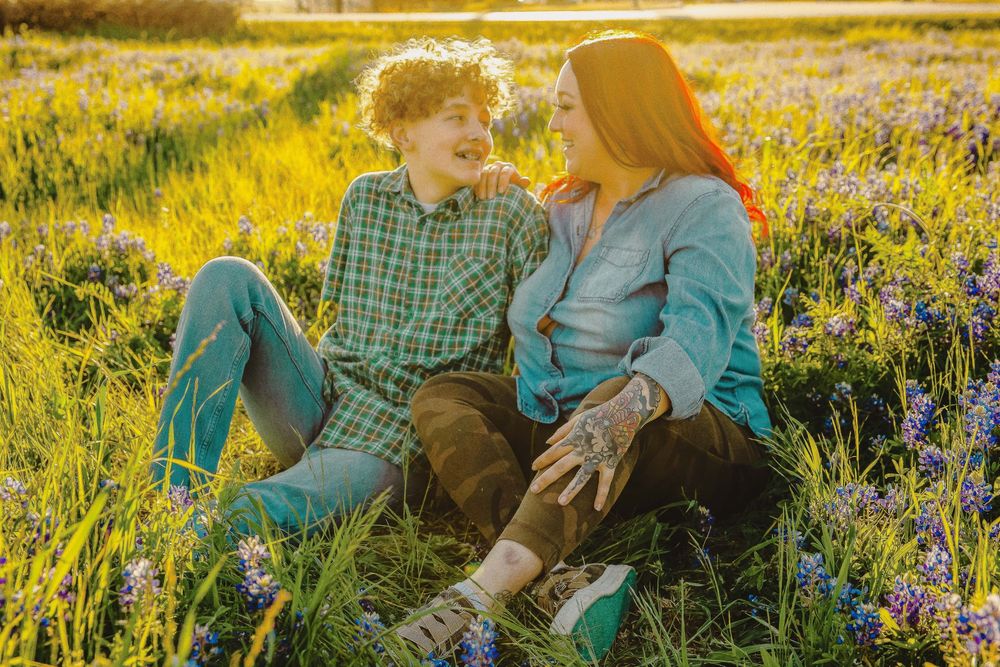 Family lounges in wildflower field during golden hour sunset photoshoot.