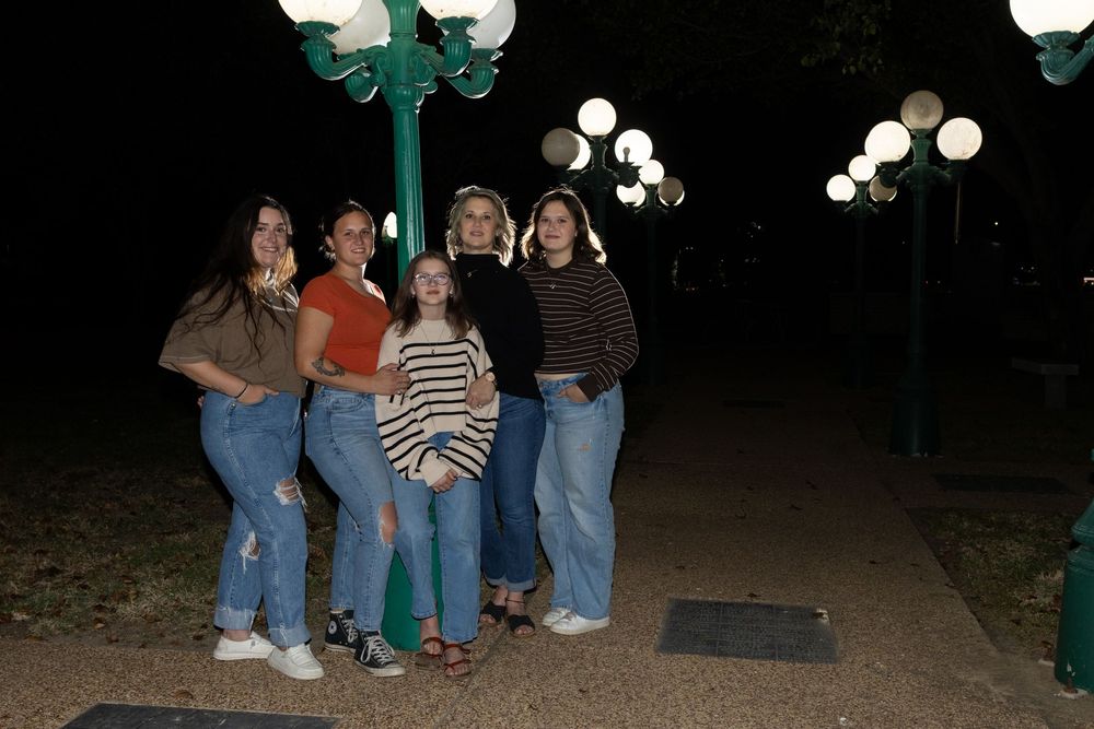 Group photo taken at night under a lamp post with illuminated decorations.