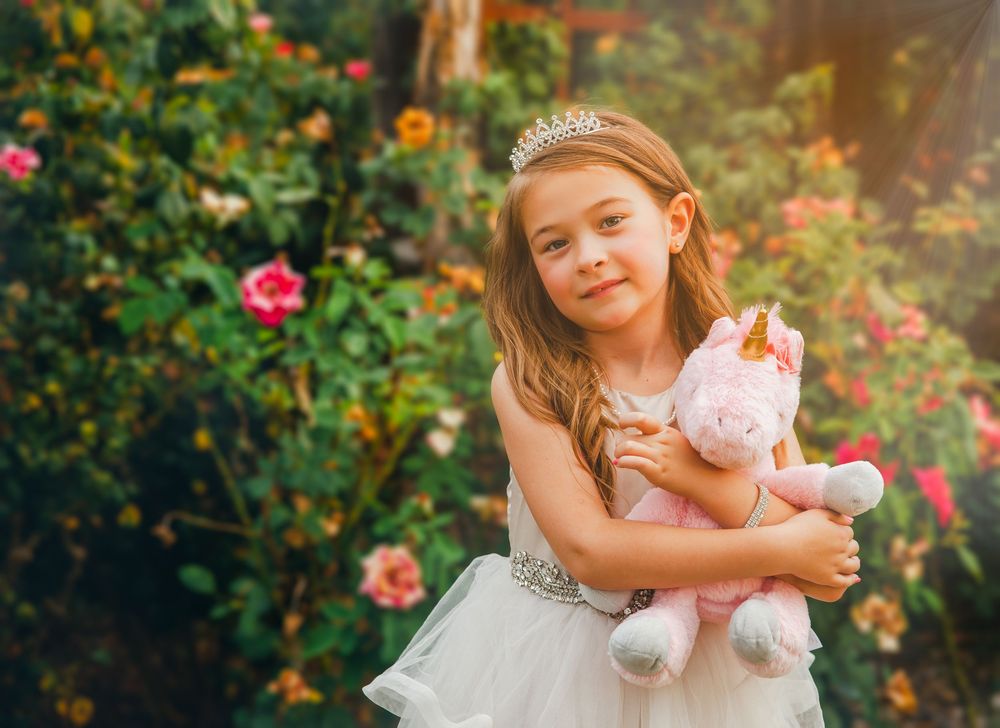 Dreamy garden portrait session features white dress and soft floral backdrop.