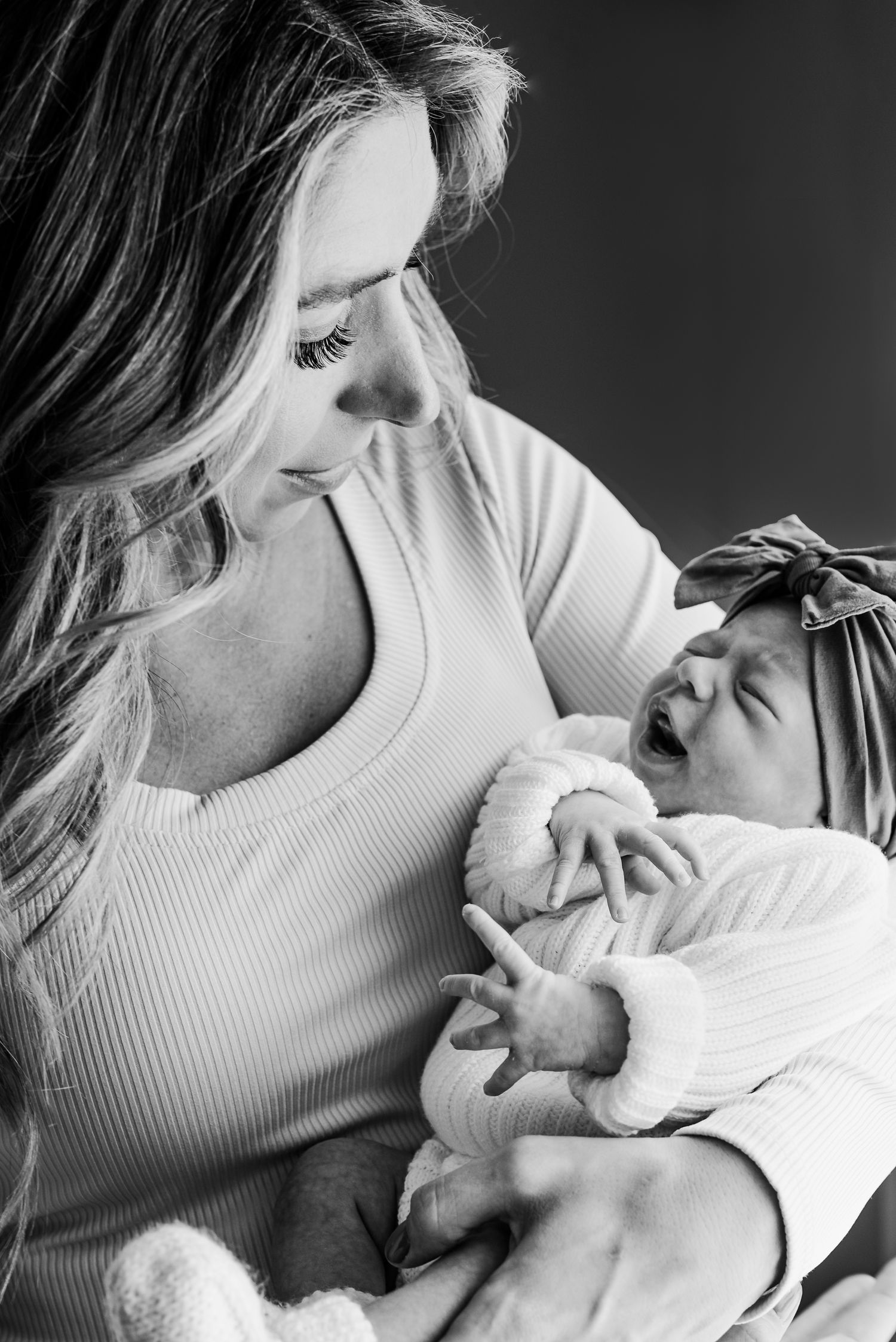A tender intimate moment captured in black and white as a person nurses their newborn baby.