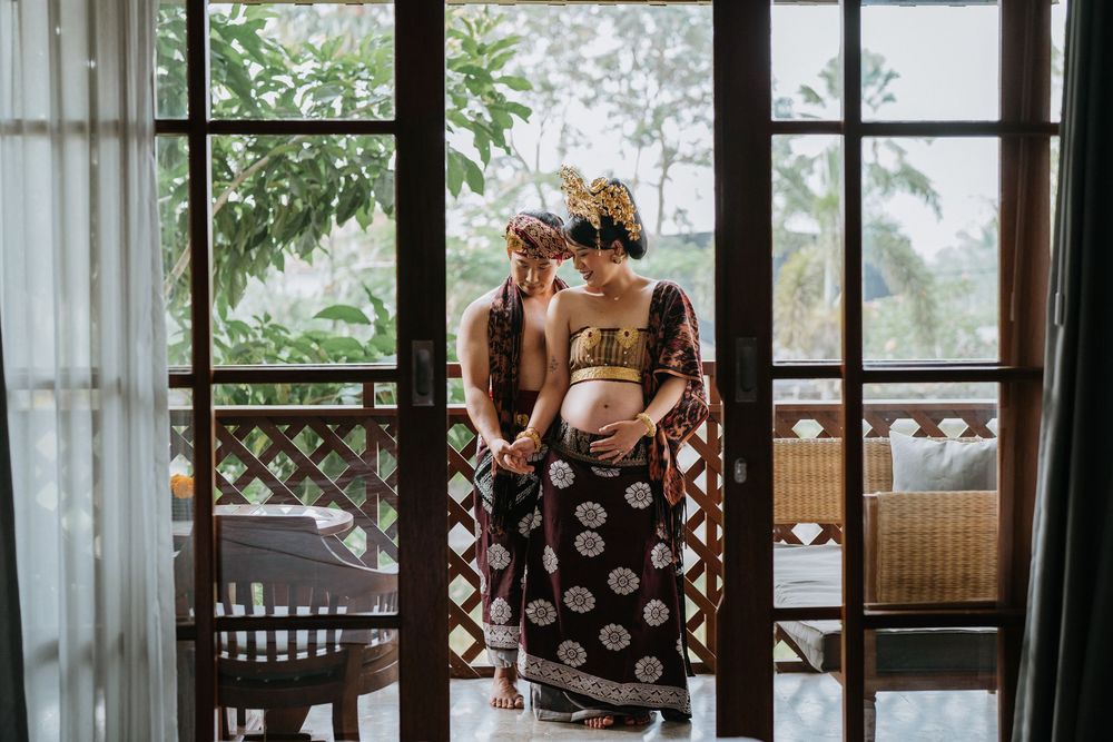 Interior view of a tropical villa with lattice windows and white curtains.