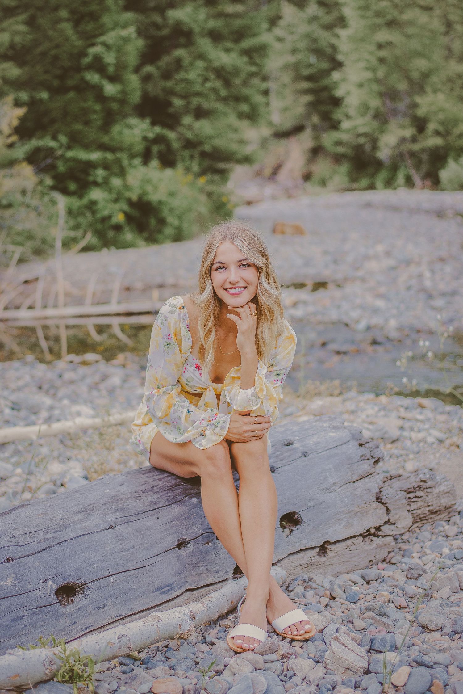 A casual portrait session on rocky terrain with soft natural lighting and mountains in the background.
