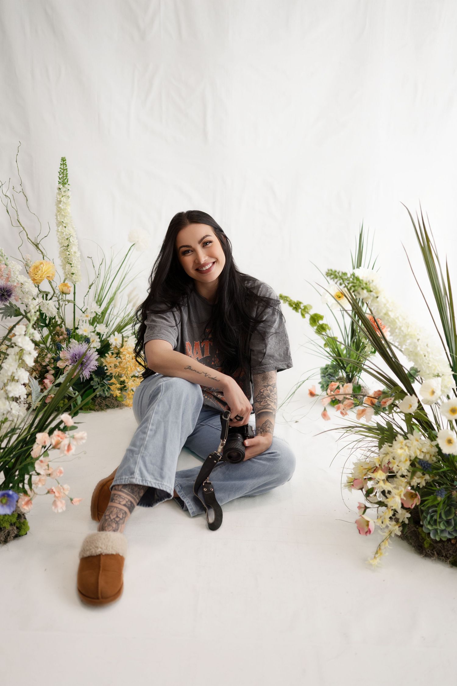 Interior photo with photographer seated in cozy corner with brick wall and boho decor .