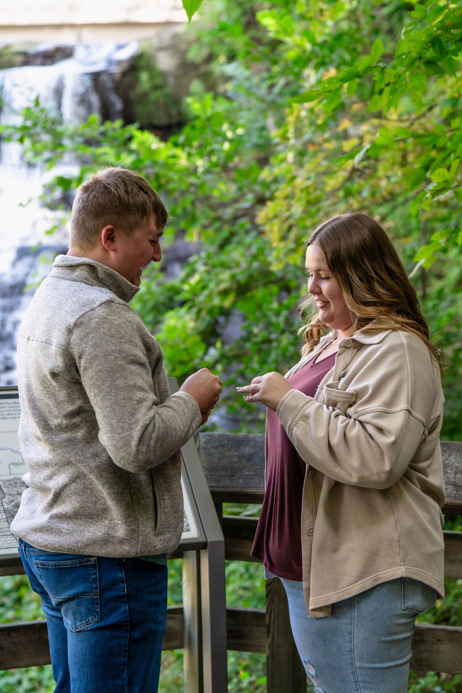 Proposal moment captured in sequence as couple stands at Brandywine falls observation deck for surprise engagement photo session