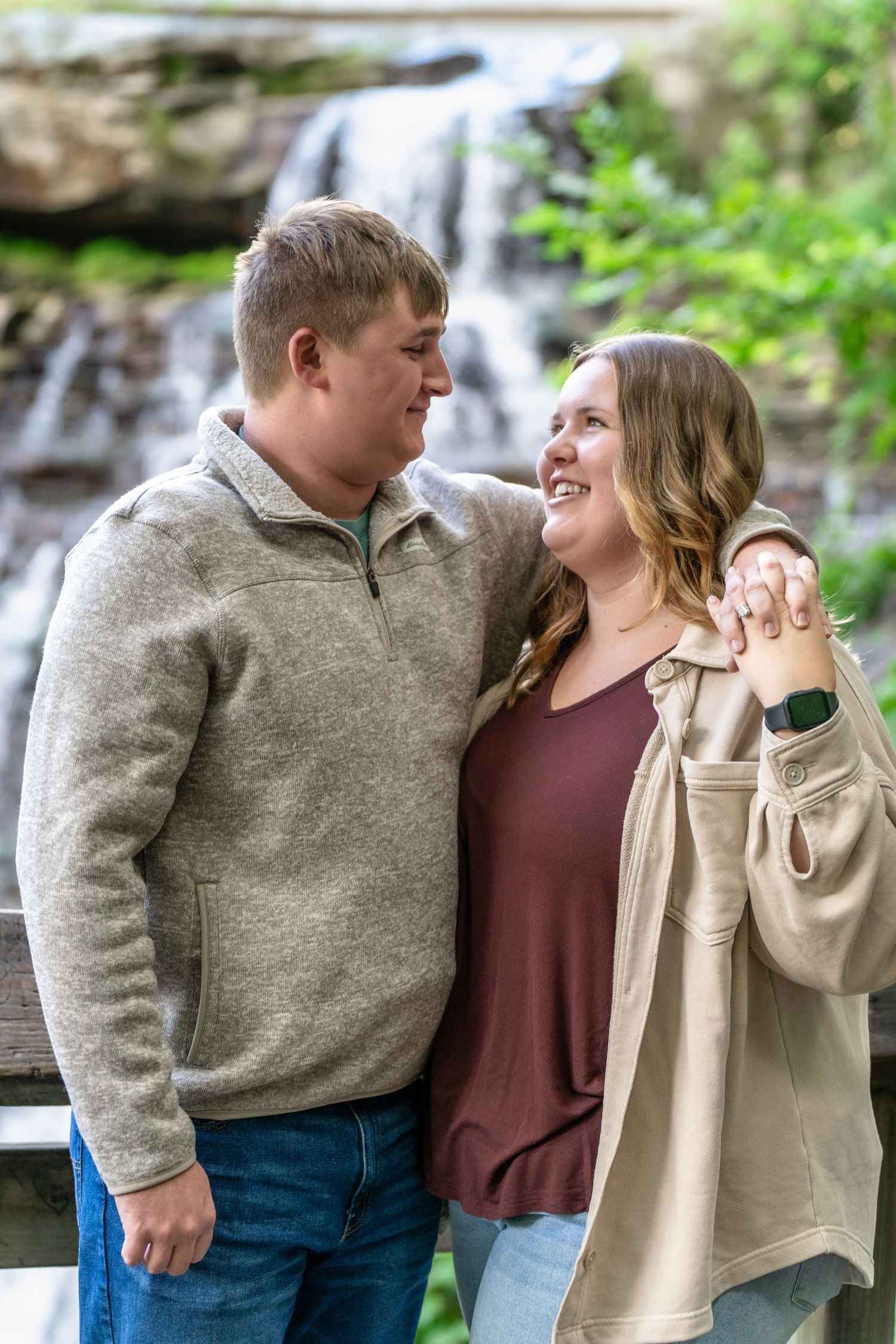 Happy couple sharing a playful romantic moment outdoors near Brandywine Falls in Ohio for surprise engagement session