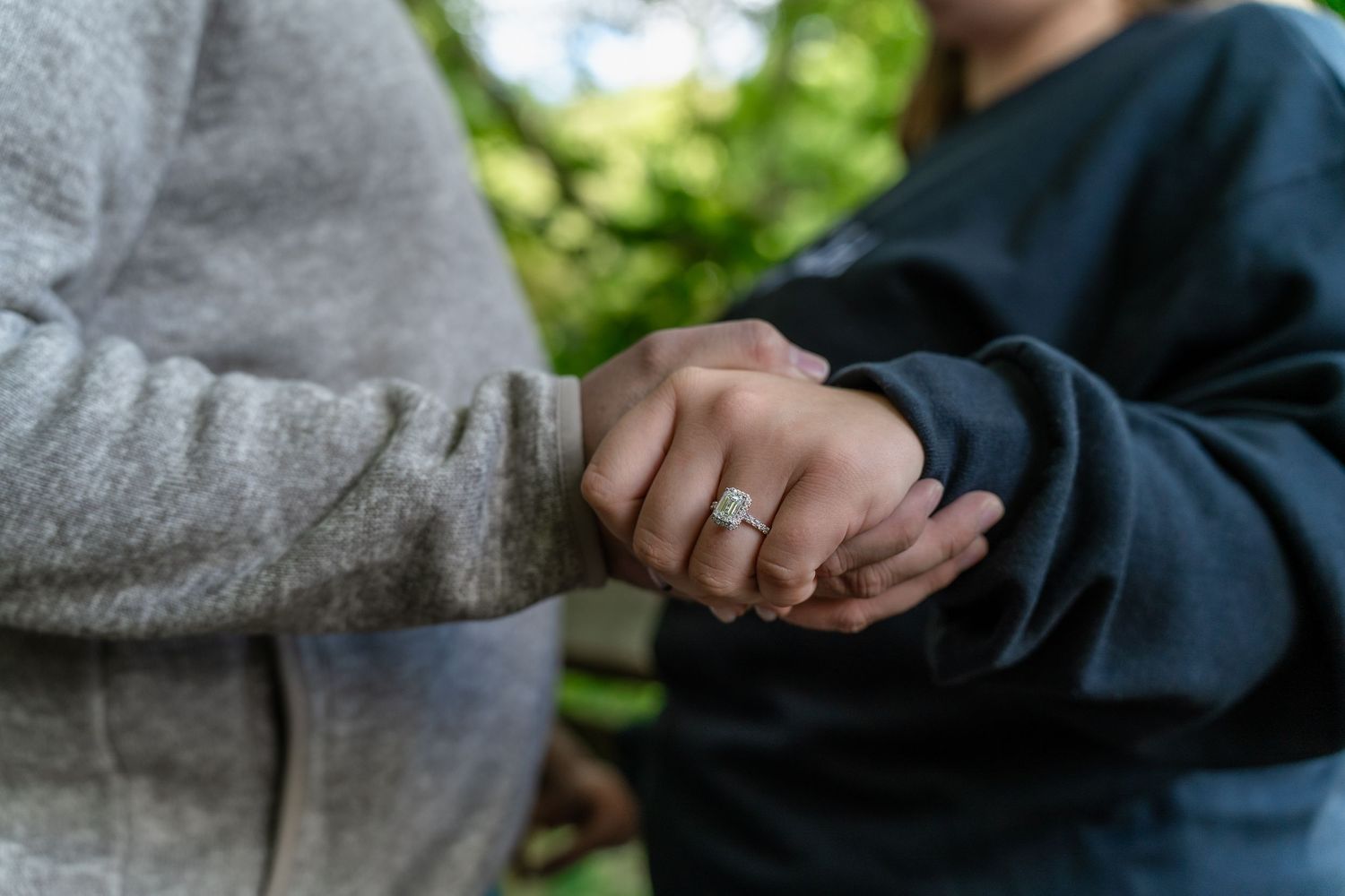 Close up of hands with engagement ring shot in natural outdoor setting at Brandywine Falls in Ohio for surprise engagement photo session