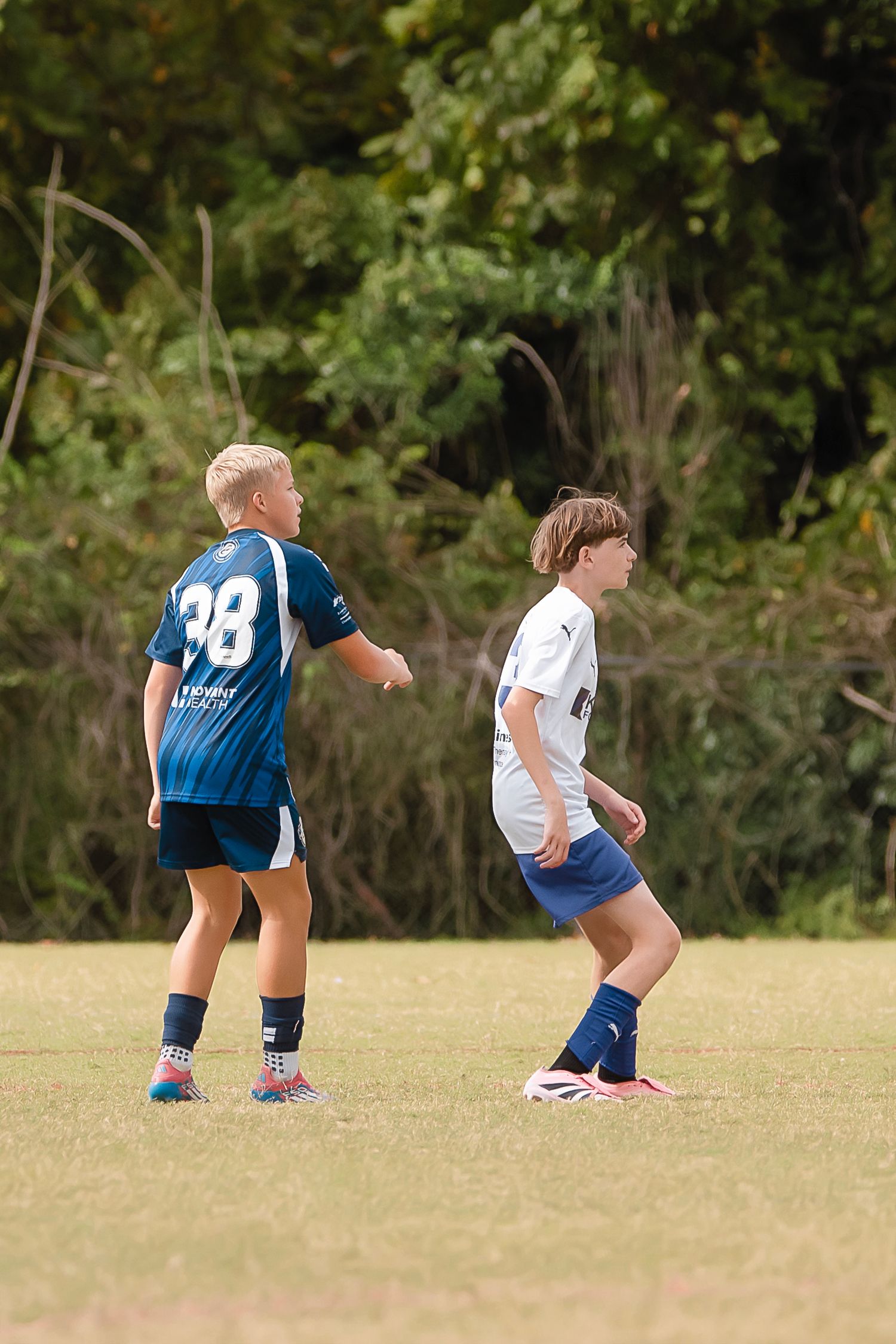 Sequence of soccer players diving and falling onto grass field during match play.