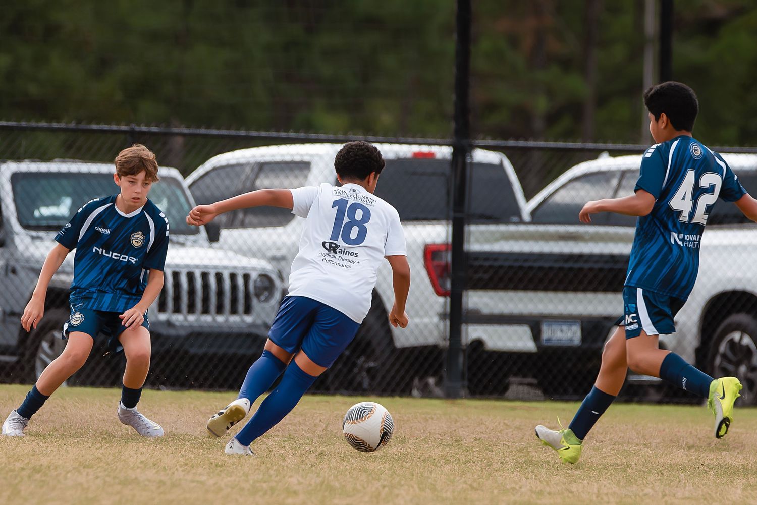 Soccer player dives to make a sliding tackle during an intense match on the field.