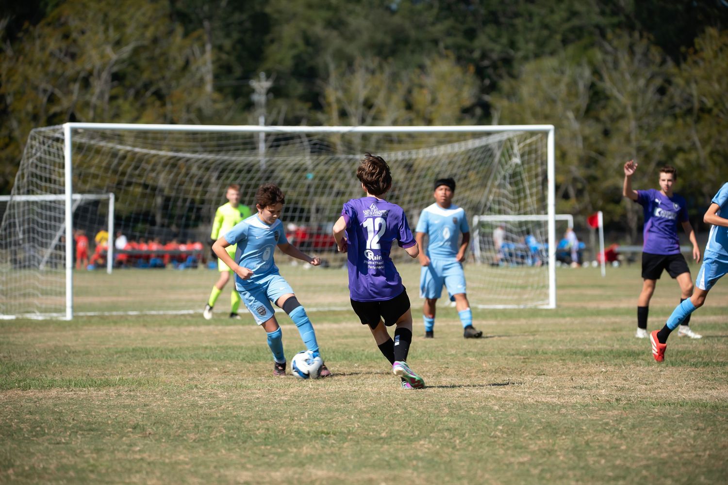 Multiple soccer games take place simultaneously on grass fields with goals visible in the background.