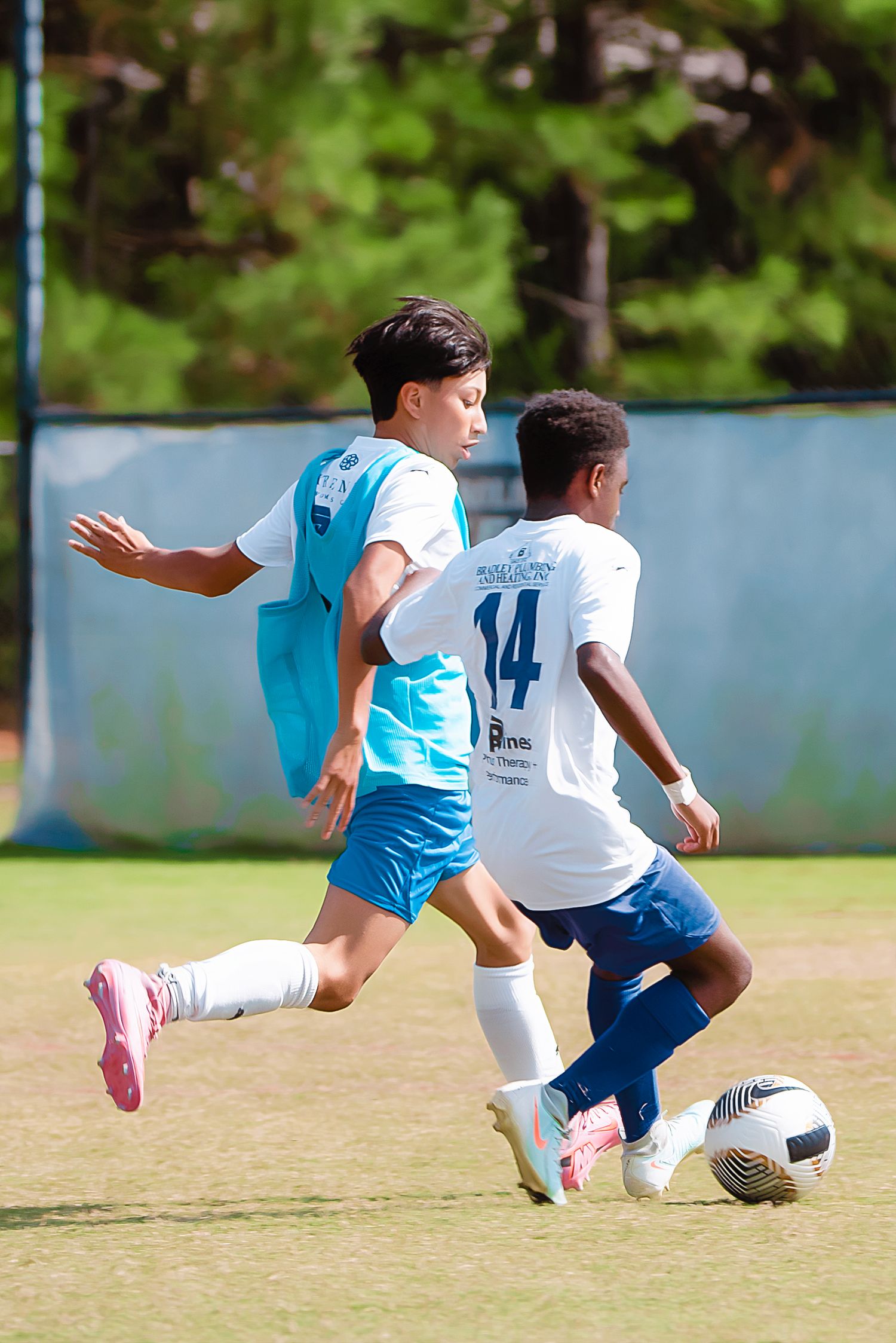 Soccer players compete for possession of the ball on a grassy field during an intense match.