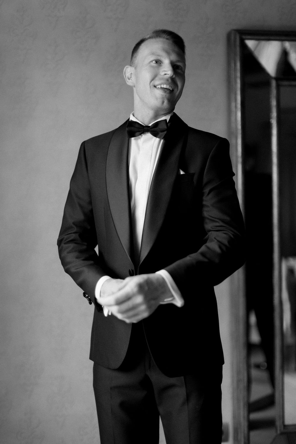 A formal sequence showing a person in a black tuxedo jacket and white shirt adjusting their attire.