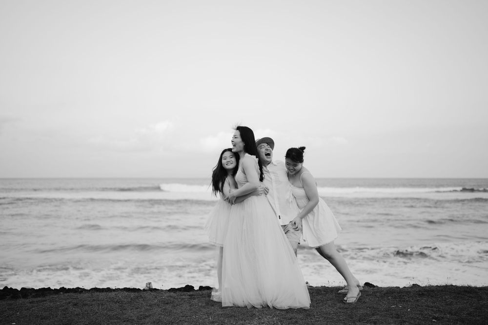 Black and white beach photography session with dramatic ocean waves in background.
