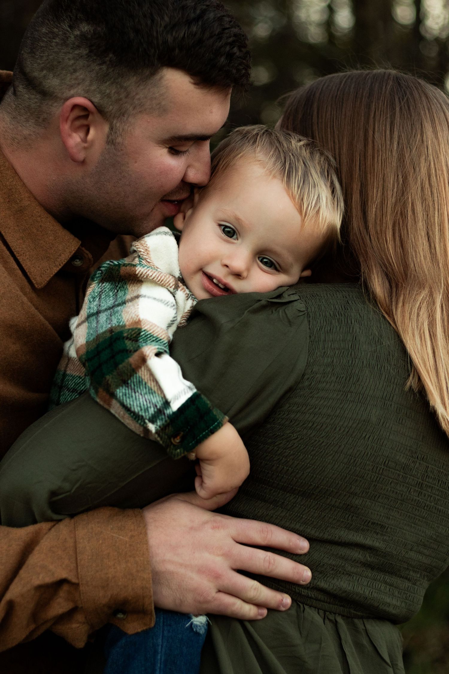 Intimate family moment captured in warm tones with gentle embraces and natural lighting.