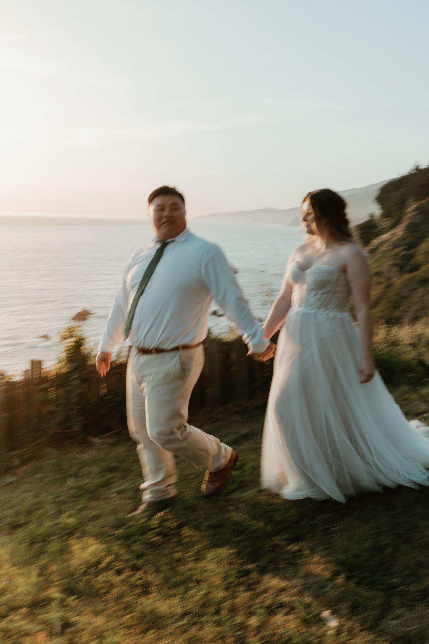 Couple embracing in warm light with mountains in background.
