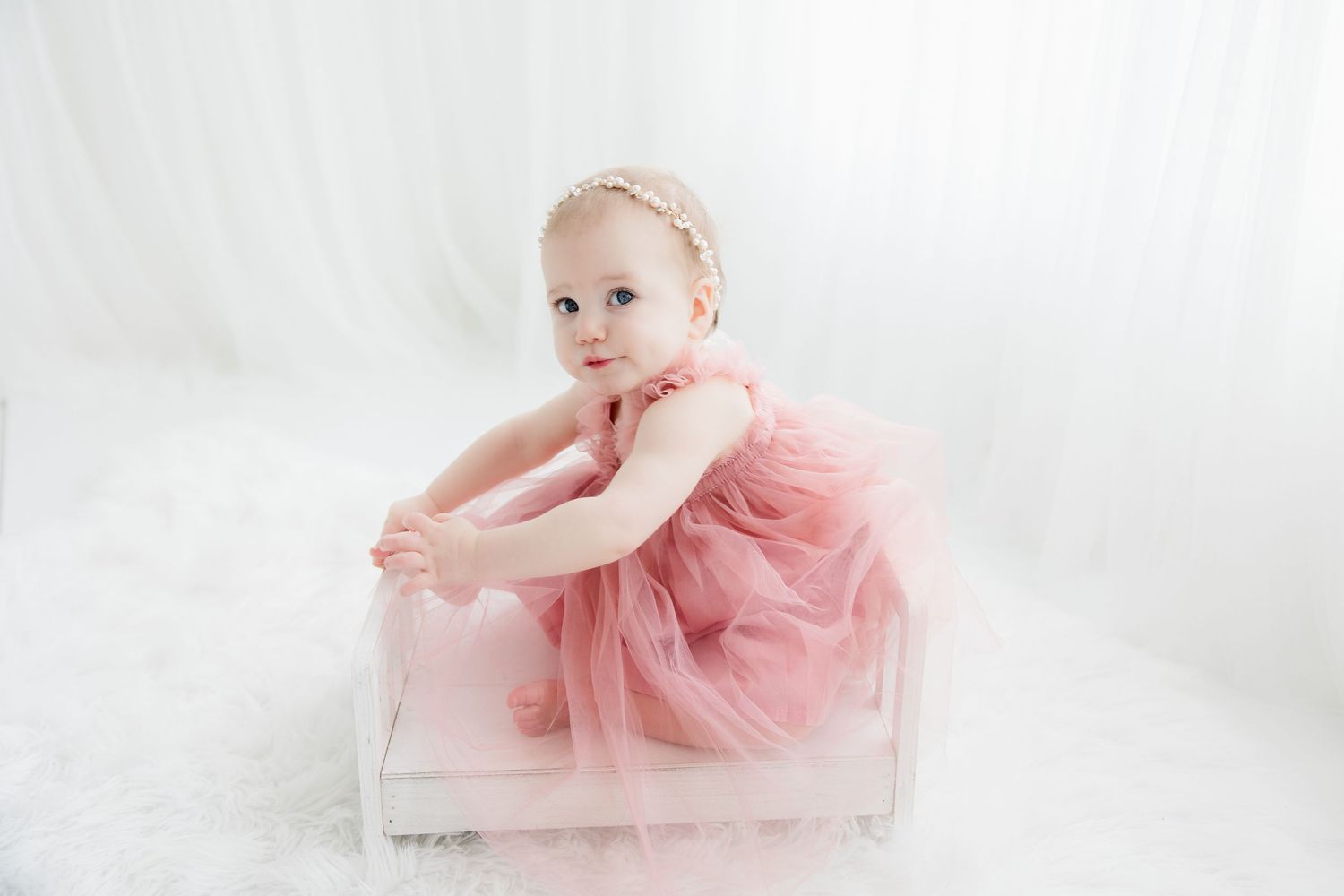 Three elegant photos of a baby in pink tulle dress against a white backdrop for studio portraits.