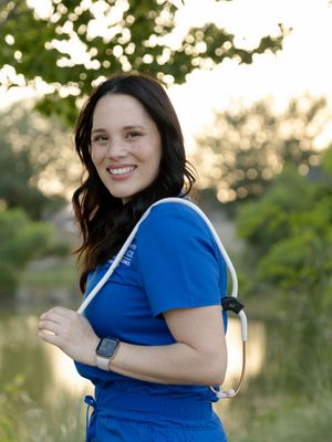 Woman in bright blue shirt poses playfully near a lake at sunset in a series of candid outdoor shots.